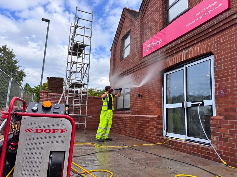 Operator using the DOFF superheated steam system on a brick wall
